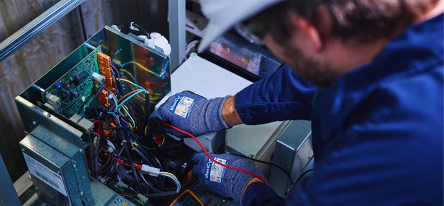 KONE technician adjusting technical equipment