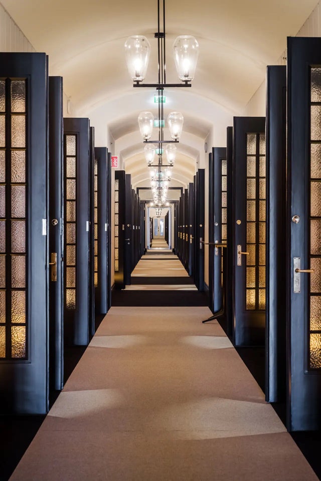 Scandic grand central corridor that has lights on the ceiling and doors on the side.