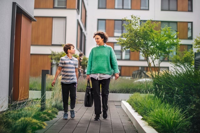 Mother and child walking in front of residential buildings