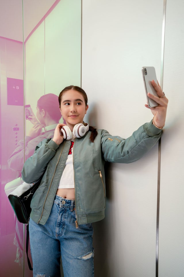 Girl inside elevator taking selfie