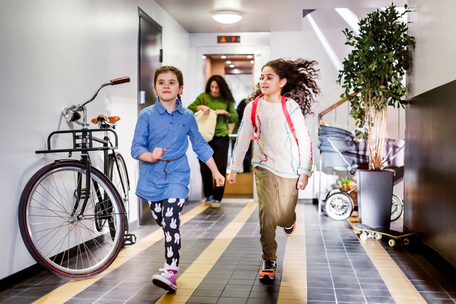 Two girls running in a corridor.