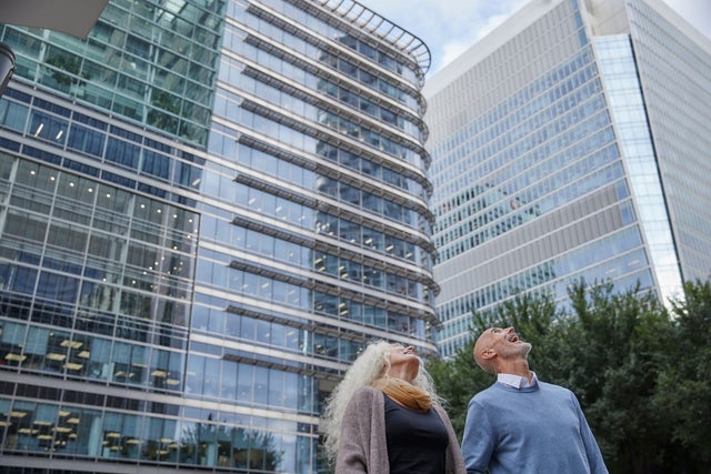 Woman and a man in front of tall buildings