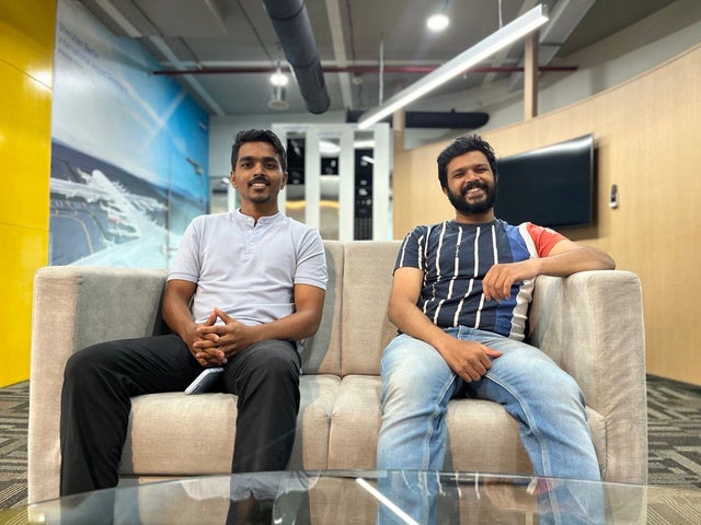 Two men sitting on a sofa.