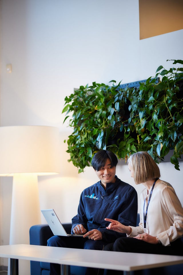 Two people discussing and looking at a laptop