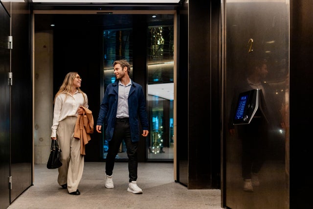 Man and woman walking in an elevator lobby
