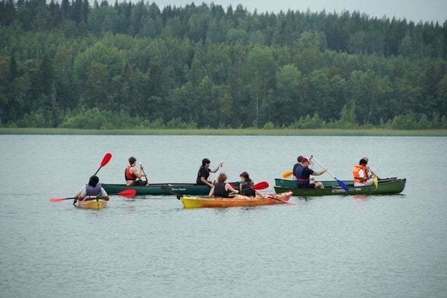 Young people canoeing on a lake. 