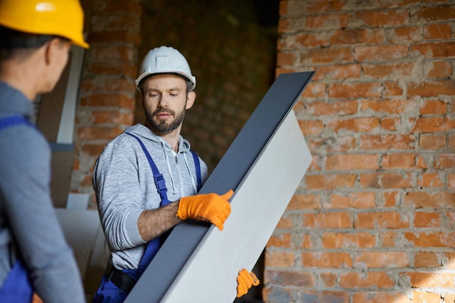 A man holding a construction component.