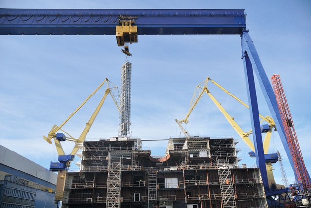 Three cranes working on a building.