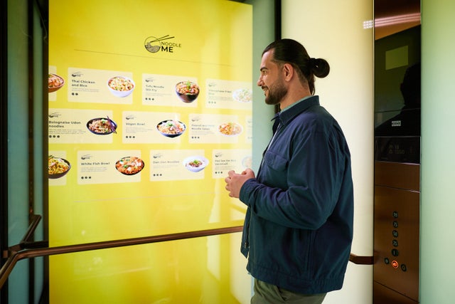 Man with food menu on the elevator wall screen