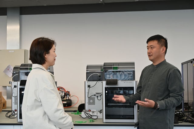 Qian and Shi talking at a university campus