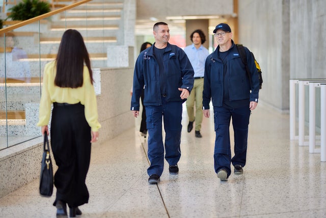Two KONE technicians walking within a modern office building.