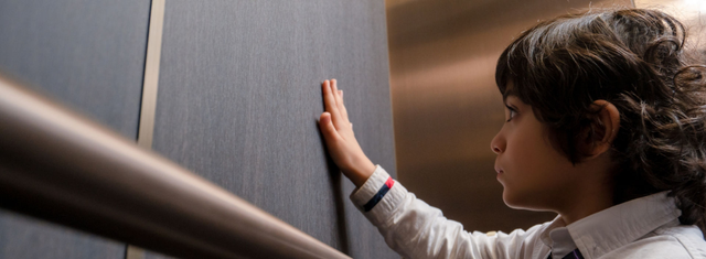 Boy touching elevator interior