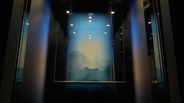 Man with food menu on the elevator wall screen