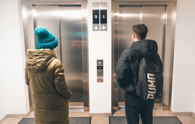 Two people waiting for an elevator