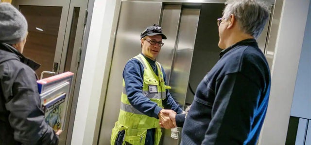 KONE technician Rami Nuorgam shakes hands with a happy customer.