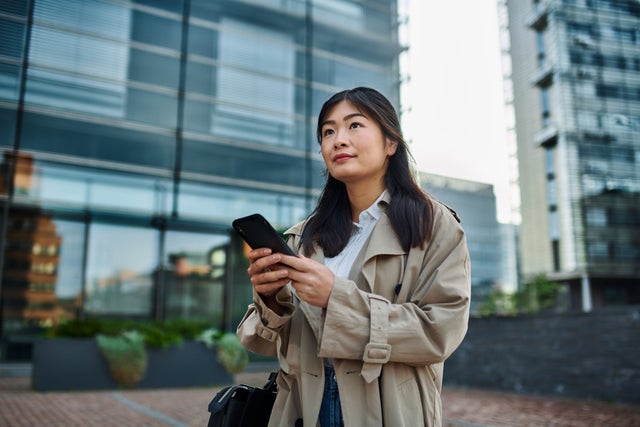 Woman with mobule phone outside a building