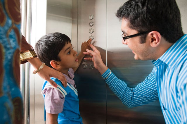 FAther and daughter pressing elevator buttons