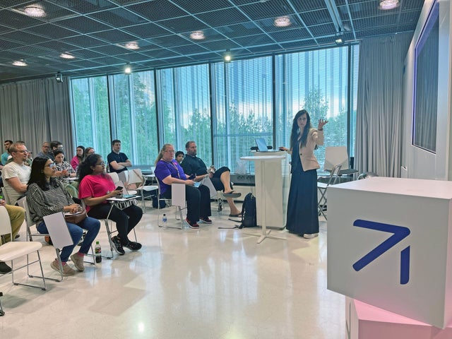 A woman talking to a small audience.