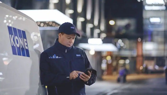 KONE technician checks his mobile phone for AI tool Technician Assistant