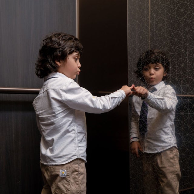 Young boy touching elevator wall