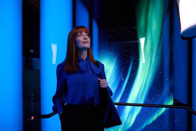 Woman in an elevator with blue background