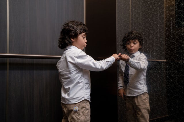 Little boy looking at his reflection inside an elevator