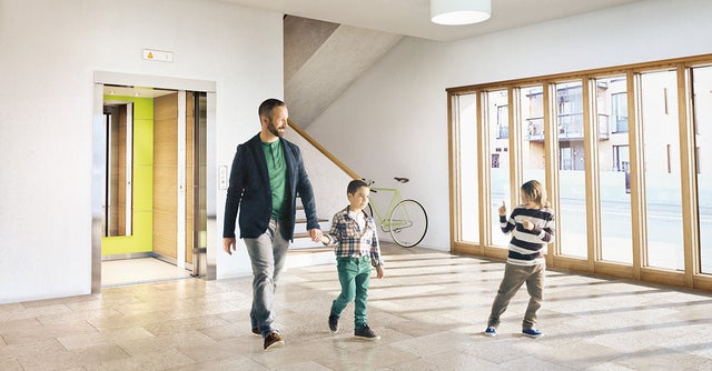 Man and two children walking from an elevator.