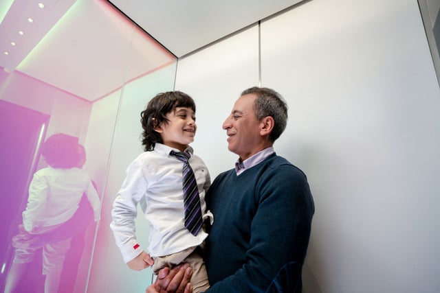 Man holding a boy in an elevator