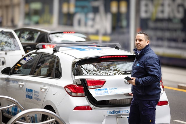 KONE technician opening the trunk of a KONE car.