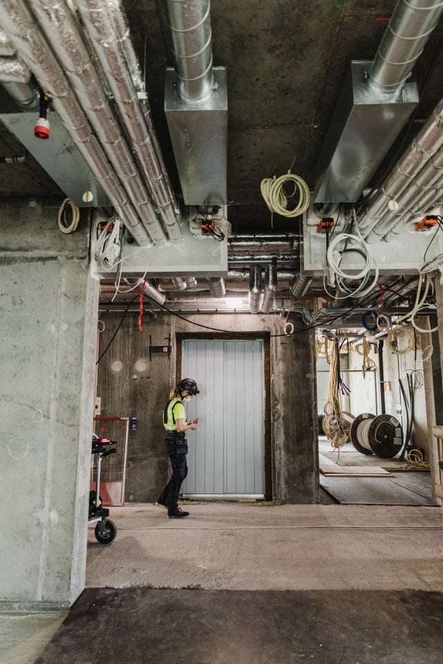Construction site worker in front of an elevator