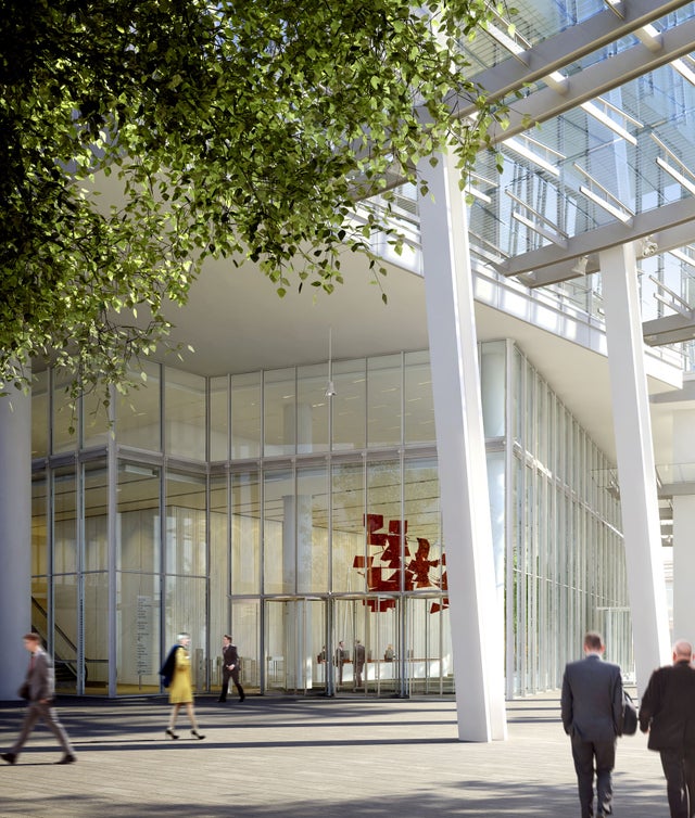 Outside view of a large glass building with people walking