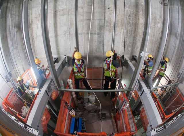 Technicians building a jump lift in the elevator shaft.