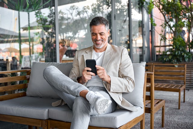 Man with mobile phone sitting on a sofa
