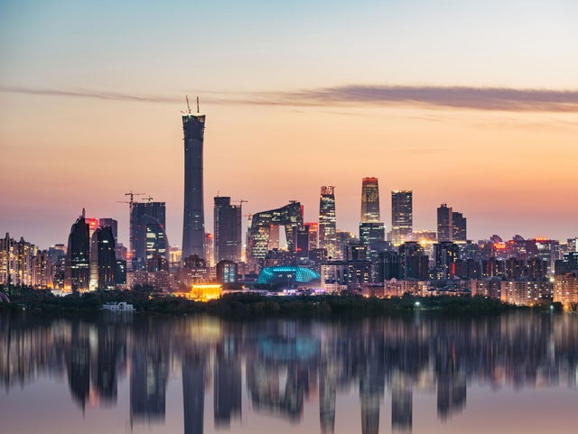A city skyline during sunset with sea in front.