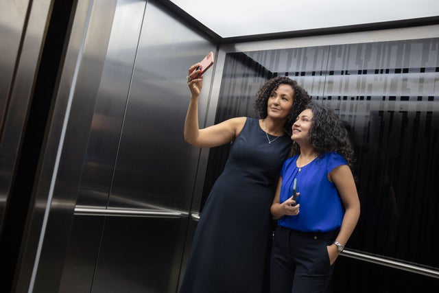 Two women in an elevator taking a selfie