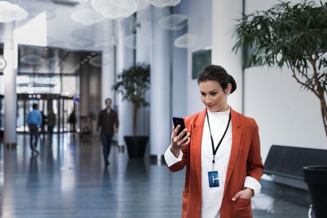 Woman looking at a phone in a lobby