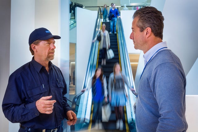 KONE escalator technician discussing with customer