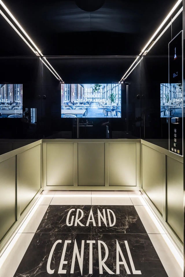 Scandic grand central elevator from the inside, screen at the back and grand central text on the floor.