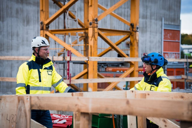 Two workers talking at a construction site. 