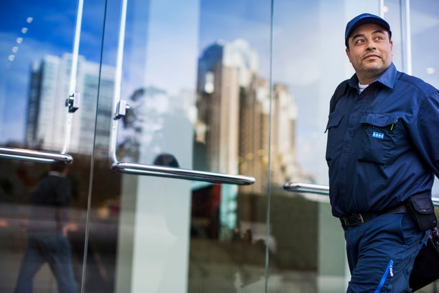 KONE technician looking to the side in front of a window.
