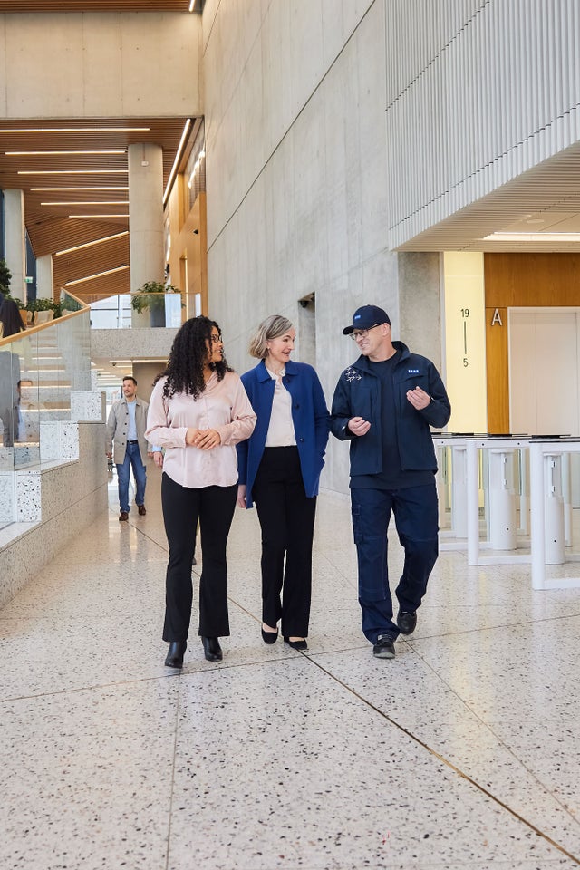 KONE technician with customers walking in a lobby