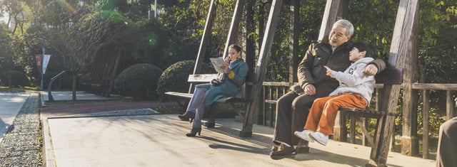 A man and a child sitting on a park bench