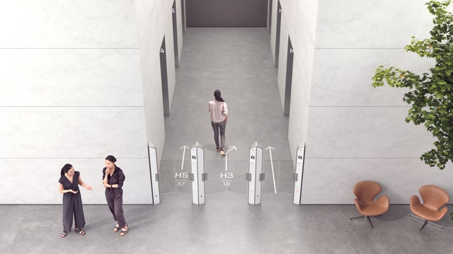 Woman going through turnstiles in lobby