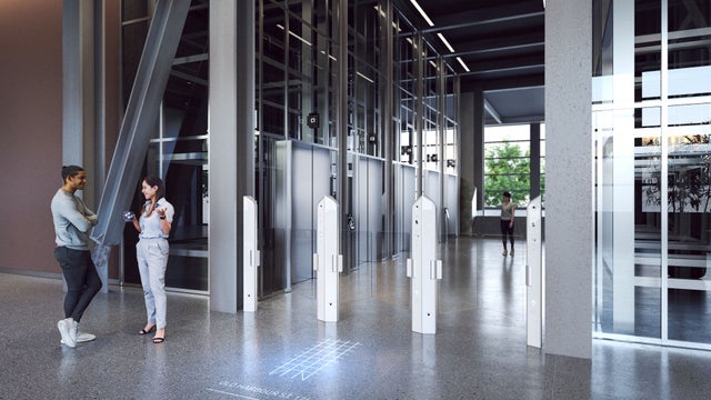 Modern turnstiles at the entrance to an elevator lobby.