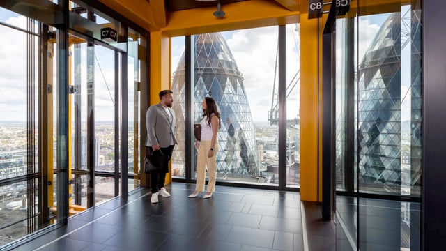 Man and woman waiting for an elevator in a high building