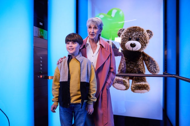 Child and grandmother in elevator with teddy bear in the background