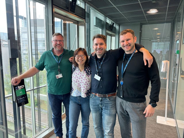Four colleagues smiling.