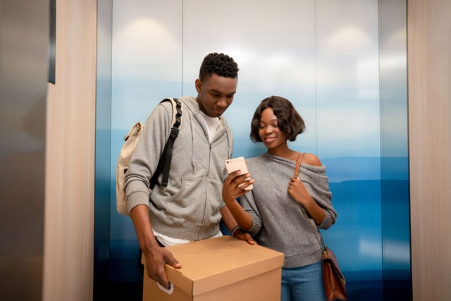 Man and woman in an elevator with a box