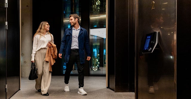 Woman and man walking in a elevator lobby