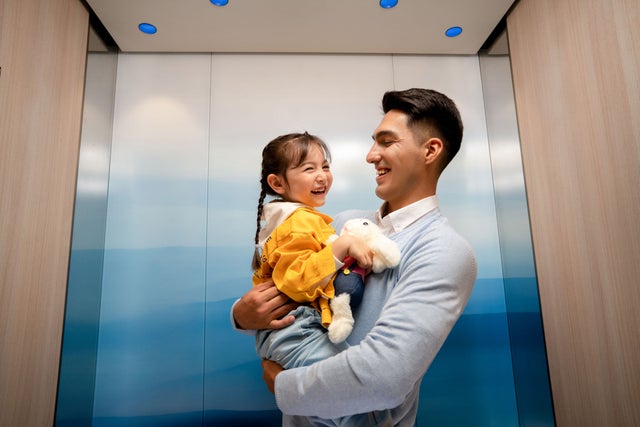 Man holding a child in an elevator